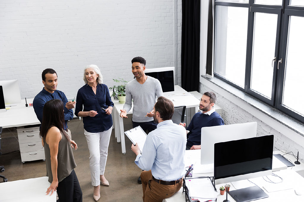 Group of office workers discussing business ideas while standing at the office